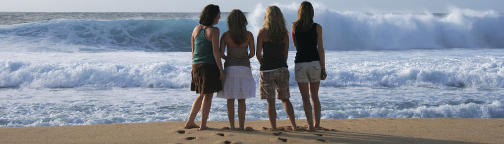 Vier Frauen stehen am Strand